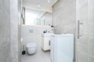 a white bathroom with a toilet and a sink at ALABAS - Stylish Central Apartment Check In 24h - Steps from Market Square & River in Wrocław +12 photos