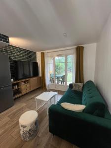Télévision ou salle de divertissement dans l'établissement L'orée des Pins TROPICO Appartement T2 en RDC avec terrasse refait à neuf