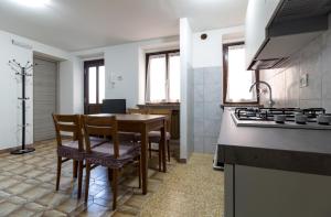 a kitchen with a table and chairs and a stove at Sonia Holiday Home - Depandance Kevin in Pont-Saint-Martin