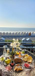 a table with food on it with the beach in the background at L'élégance du Large in Cayeux-sur-Mer