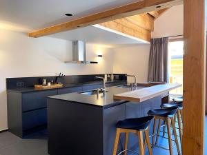 a kitchen with blue cabinets and bar stools at Casa-Le Cherk Chalet 300m2 jacuzzi sauna Vars in Vars