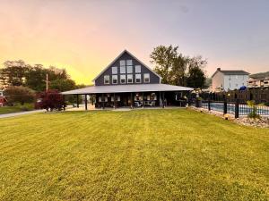 a building with a large grass field in front of it at Waterfront Resort Escape in Roscoe