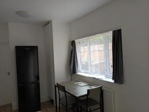 un tavolo e delle sedie in una stanza con una finestra di Private En-Suite Room by Christchurch Park a Ipswich