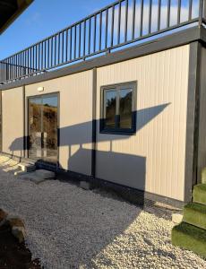 una casa con due finestre sul lato di Anastasi Tiny Homes a Kakopetria