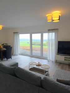 a living room with a couch and a flat screen tv at Panorama trifft Gemütlichkeit in Nümbrecht