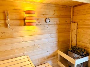 a corner of a wooden cabin with a clock on the wall at Wohlfühl Oase mit Sauna vor den Toren Berlins in Nauen