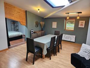 a dining room with a table and chairs and a bed at appartement Plume de repos in Marboué