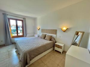 a bedroom with a large bed and a window at SA CALETA - Apartamento con piscina y junto a la playa in Cala en Blanes +23 photos