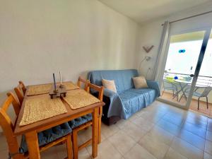 a living room with a couch and a table at SA CALETA - Apartamento con piscina y junto a la playa in Cala en Blanes