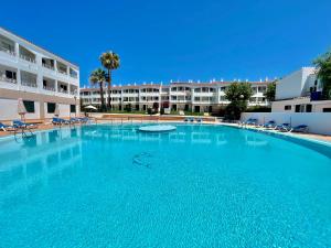 a large swimming pool in front of a building at SA CALETA - Apartamento con piscina y junto a la playa in Cala en Blanes