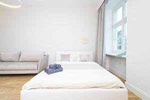 a white bedroom with two beds and a couch at Central Lux Apartment - Heart of the Old Town Check In 24h in Wrocław