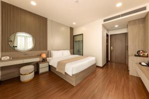 a hotel room with a bed and a mirror at MAI Luxury Hotel Ninh Binh in Ninh Binh