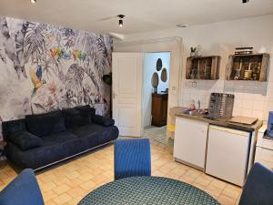 a living room with a couch and a kitchen at appartement Plume de repos in Marboué