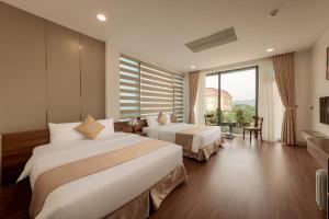 a hotel room with two beds and a large window at MAI Luxury Hotel Ninh Binh in Ninh Binh +53 photos