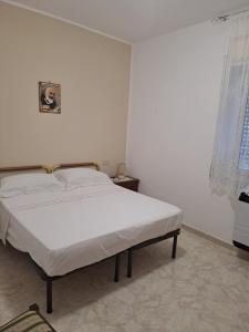a white bedroom with a bed in a room at ANGELA Rooms in Marineo