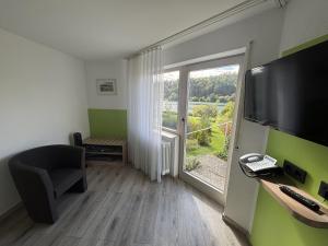 a room with a desk with a computer and a window at Hotel Restaurant Sättele in Steißlingen
