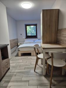 a bedroom with a bed and a table and chairs at Noclegi u Alicji in Gołuchów