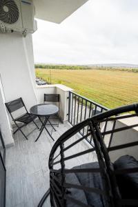 Un balcón con sillas, una mesa y un campo en Vuls Apartments, en Sibiu