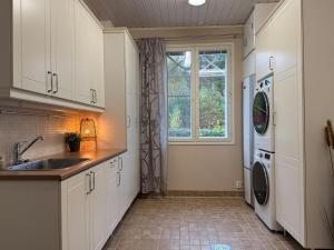 a kitchen with a sink and a washing machine at Rovaniemi Santas Home in Rovaniemi