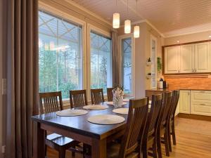 a dining room table with chairs and a large window at Rovaniemi Santas Home in Rovaniemi
