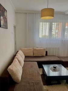 una sala de estar con un sofá y una mesa en Comfy Downtown Apartment Prishtina, en Pristina