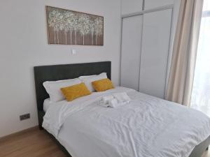 a white bed with yellow pillows in a bedroom at Tatu Nest in Tatu City