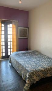 a bedroom with a large bed with purple walls at Lar dos Bem-ti-vis in Niterói