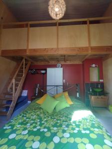 a bedroom with a bed with green and yellow pillows at chateau d'eau logement insolite in Tournemire