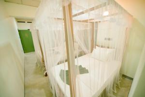 ミリッサにあるIsland Spoon Mirissaの白いカーテンが壁に掛けられた部屋