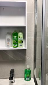 a bathroom sink with a bottle of mouthwash and toothpaste at The Central Hub Luton A in Luton