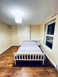 a bedroom with a bed in a room with a window at The Central Hub Luton A in Luton +7 photos