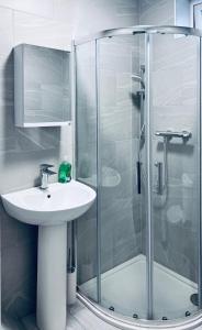 a bathroom with a sink and a glass shower at The Central Hub Luton A in Luton