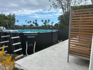 a swimming pool in a backyard with a fence at La Petite Case Tomi in Saint-Louis