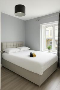 una camera da letto bianca con un letto grande e una finestra di Temple Bar 3BR Prime Location a Dublino
