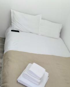 a white bed with a pile of towels on it at Relax Apartament Bicaz in Bicaz