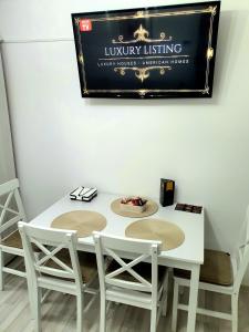 a white table with two chairs and a sign on the wall at Relax Apartament Bicaz in Bicaz