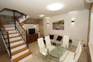a living room with a glass table and a staircase at Villa Stone Garden Escape with jacuzzi in Split