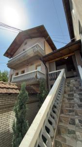 a building with a staircase leading up to a house at Holiday home in Mitrovicë