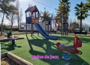 a playground with a slide in a park at Mobilhome Montourey 4 étoiles 3 chambres 2 salles de bain in Fréjus