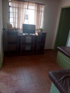 a room with a desk with a television on it at Hospedagem e Pousada Cachoeira Paulista in Cachoeira Paulista