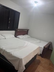 two beds sitting next to each other in a room at Hospedagem e Pousada Cachoeira Paulista in Cachoeira Paulista +1 photo