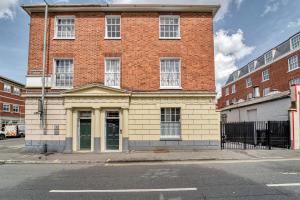 un grand bâtiment en briques au coin d'une rue dans l'établissement WhiskAwayHomes Shaw Street Apartment 1, à Worcester
