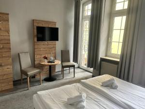 a hotel room with a bed and a table and chairs at Nostalgie Altstadthotel Kornpforte in Koblenz
