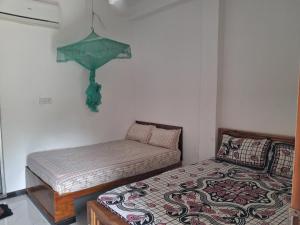 a small bedroom with a bed and an umbrella on the wall at Nethu beach villa in Trincomalee