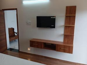 ein Wohnzimmer mit einem Fernseher an der Wand in der Unterkunft Le Sasvik in Kodaikanal