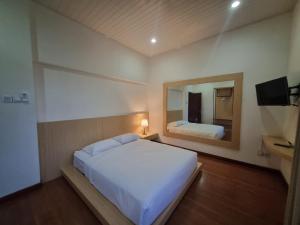 a bedroom with a large white bed and a mirror at Serambi Buya Syariah 5 BR in Jetis