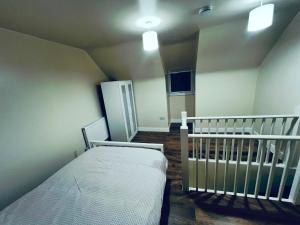 a small bedroom with a crib and a room with a cribintend at The Central Hub Luton B in Luton