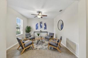 a living room with chairs and a table and a ceiling fan at Spacious Getaway Near Apollo Beach home in Gulf City