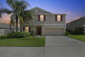 a house with a palm tree and a driveway at Spacious Getaway Near Apollo Beach home in Gulf City