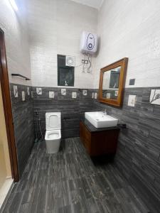 a bathroom with a toilet and a sink and a mirror at Scenic Lanka Luxury Rooms in Dehiwala